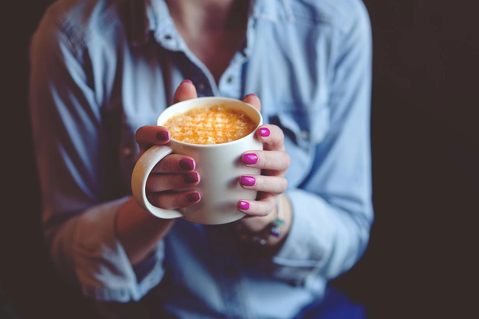 H&auml;nde die eine Tasse Caf&eacute; halten.