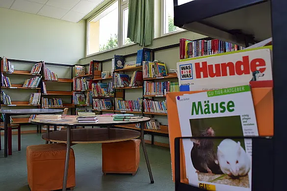 Bücherei mit Regalen und einen Tisch mit Stühlen